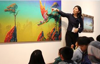 미술품에 대해 설명하고 있는 사람과 듣고 있는 아이들 사진