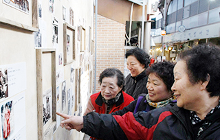 시장사람들이 미술품을 관람하고 있는 사진